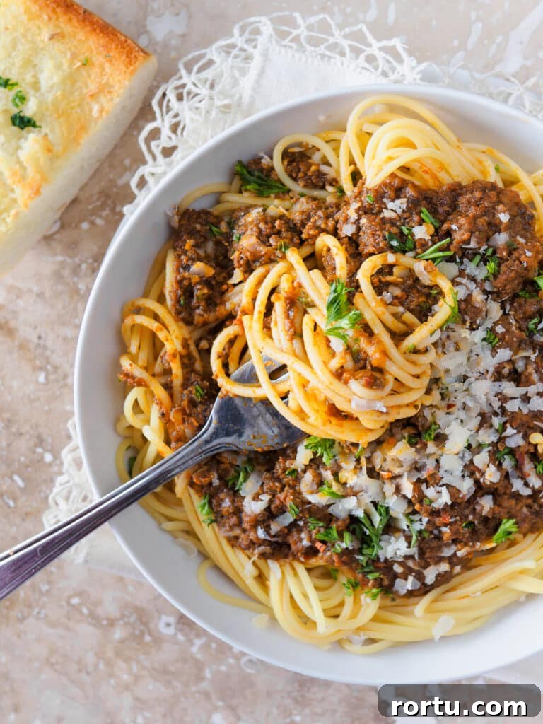 Bowl of spaghetti topped with meat sauce.
