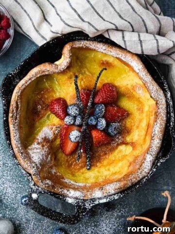 Overhead picture of a vanilla Dutch baby with fruit in the middle.