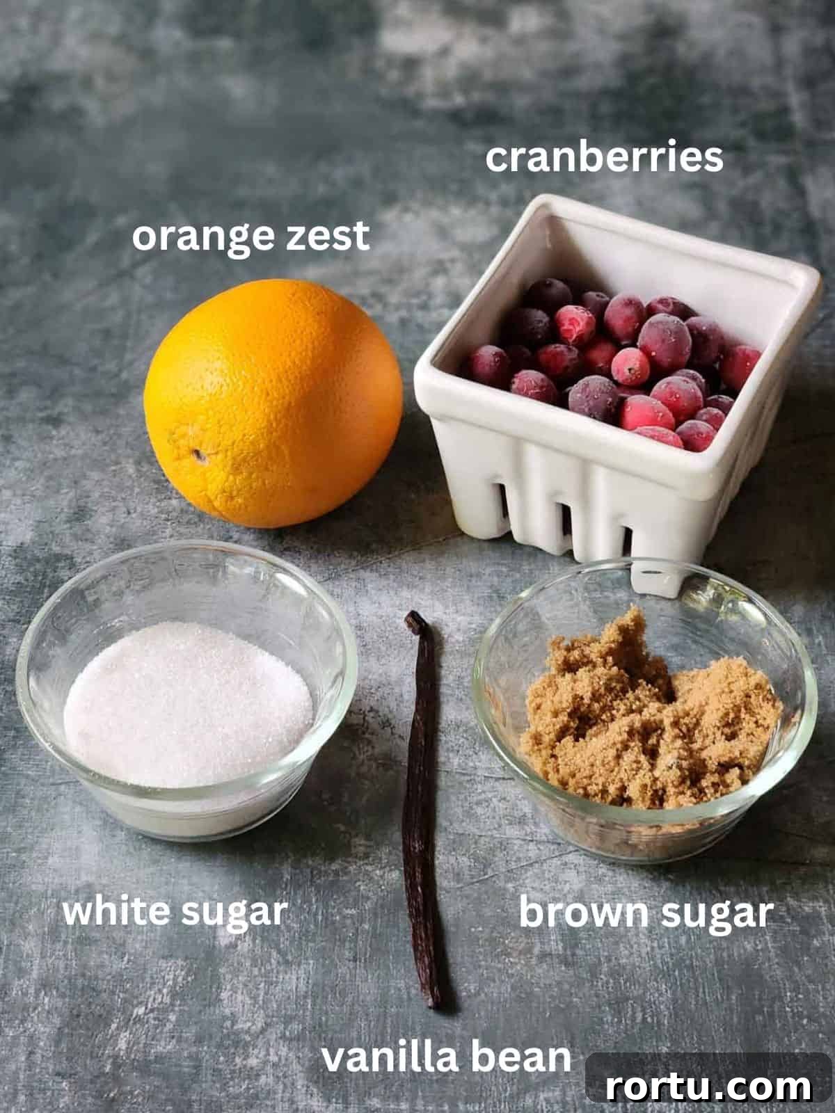 Ingredients for vanilla cranberry compote on a grey surface.