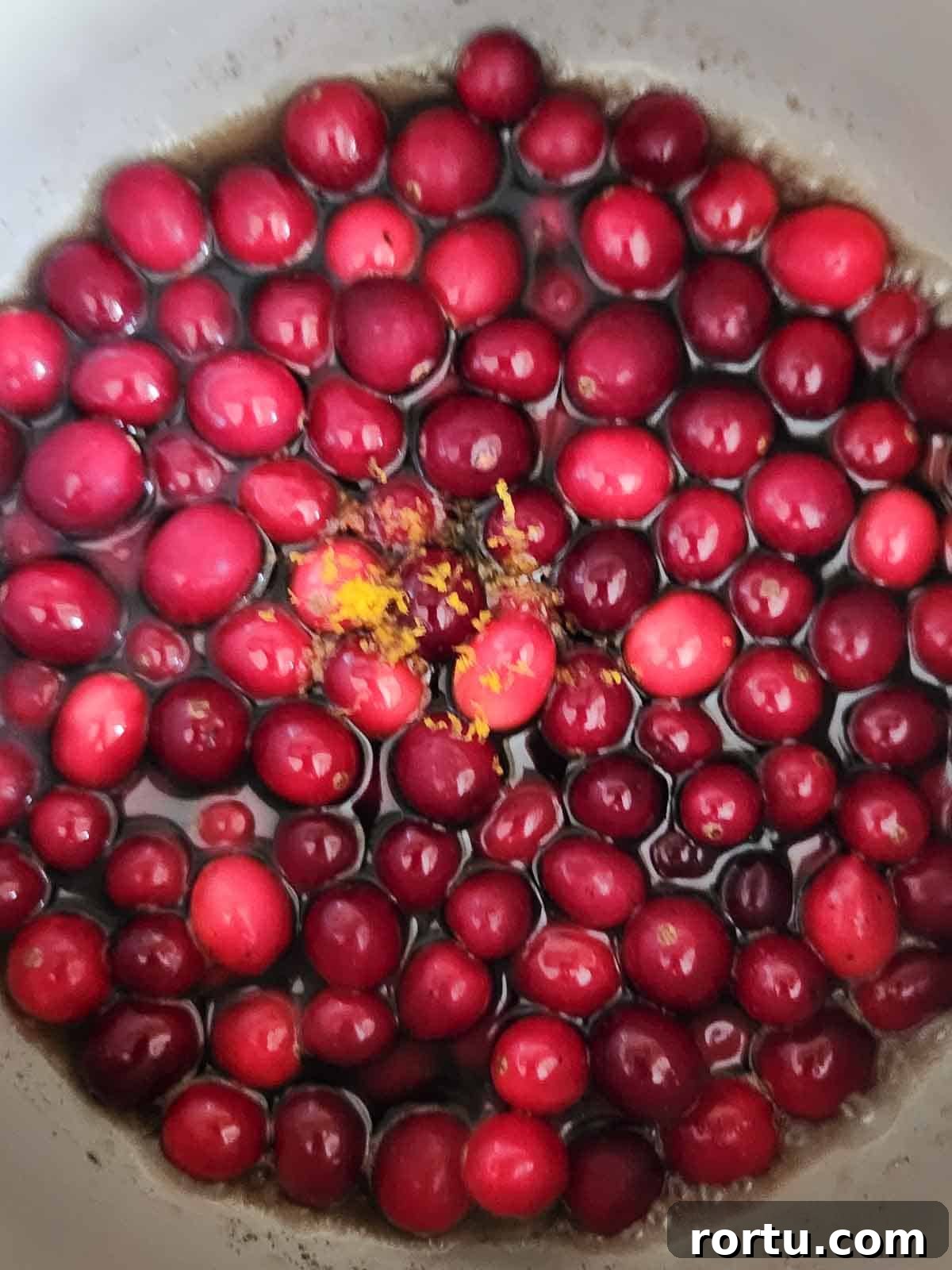 Cranberries, and syrup in a pot.