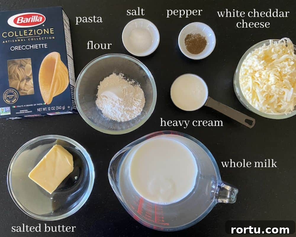 Creamy White Cheddar Macaroni and Cheese Recipe 3 creamy white cheddar mac and cheese ingredients on black countertop with text
