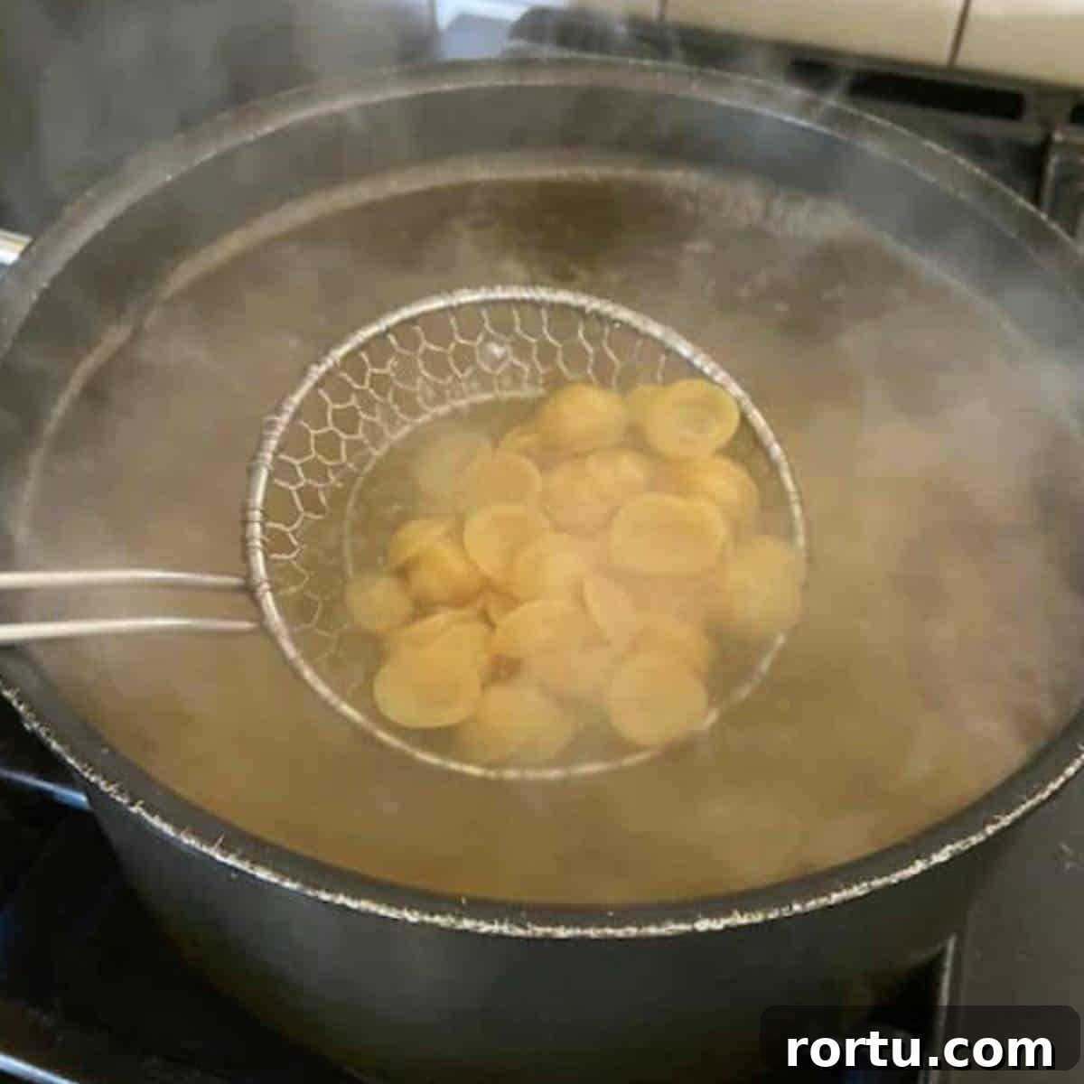 Creamy White Cheddar Macaroni and Cheese Recipe 4 Pasta boiling in pot.