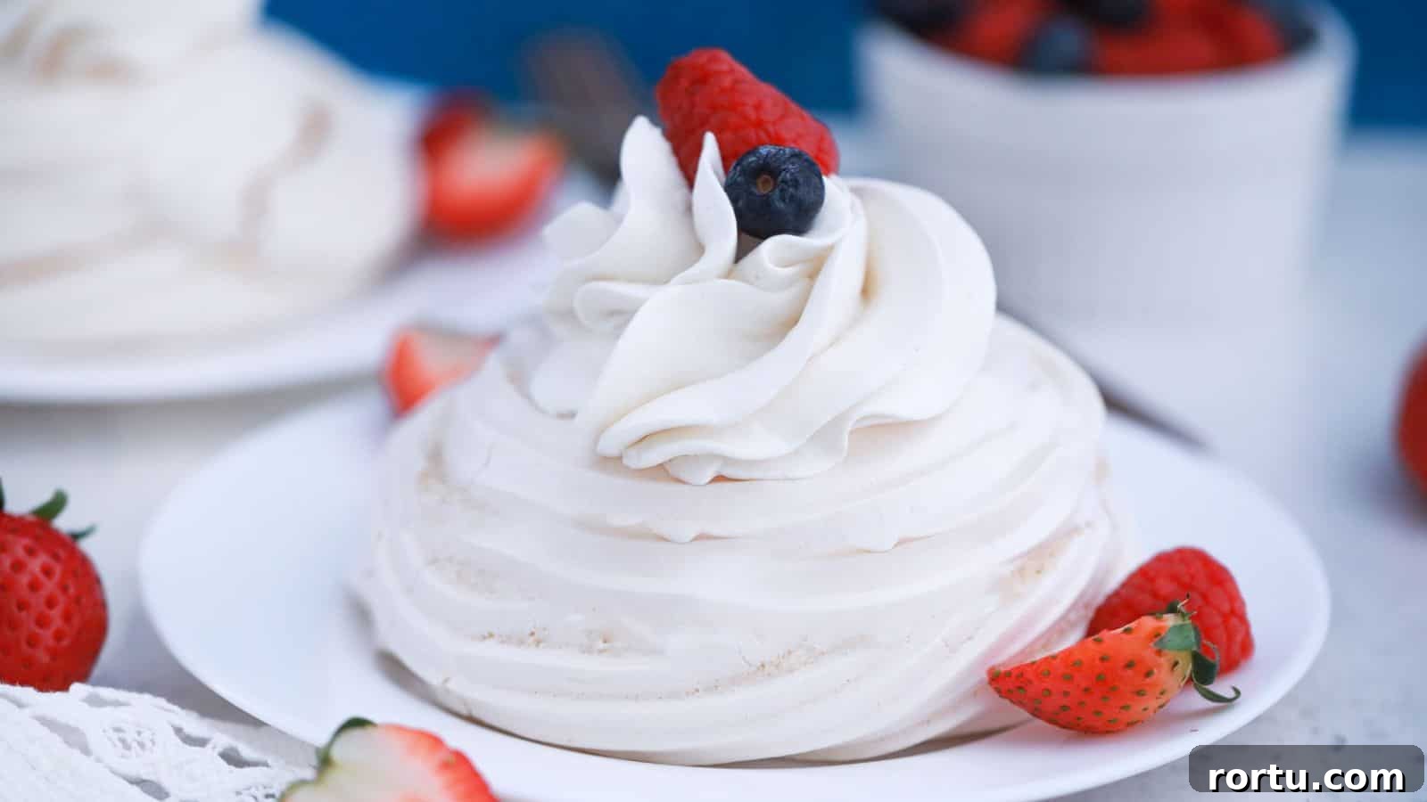 Mini pavlova nests with whipped cream and berries.