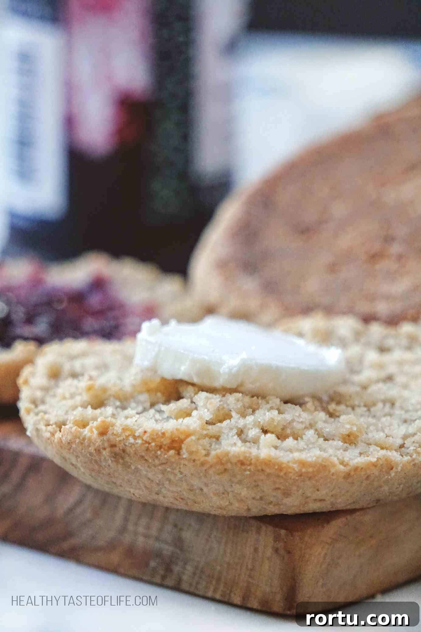Homemade Gluten Free English Muffin with a piece of butter on top showing up-close crumb texture