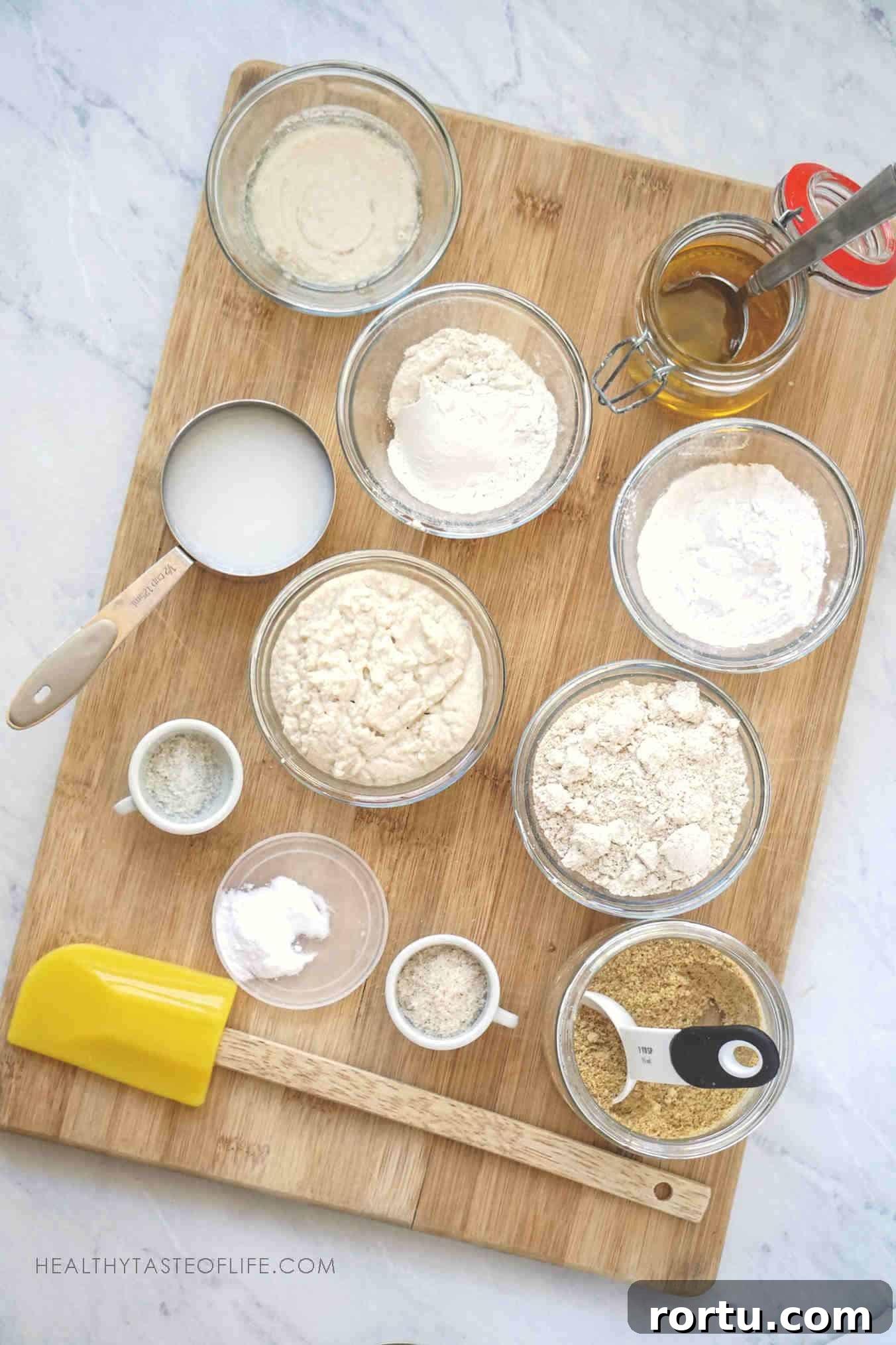 Measured Ingredients spread on a wooden board needed for making these gluten free sourdough English muffins.