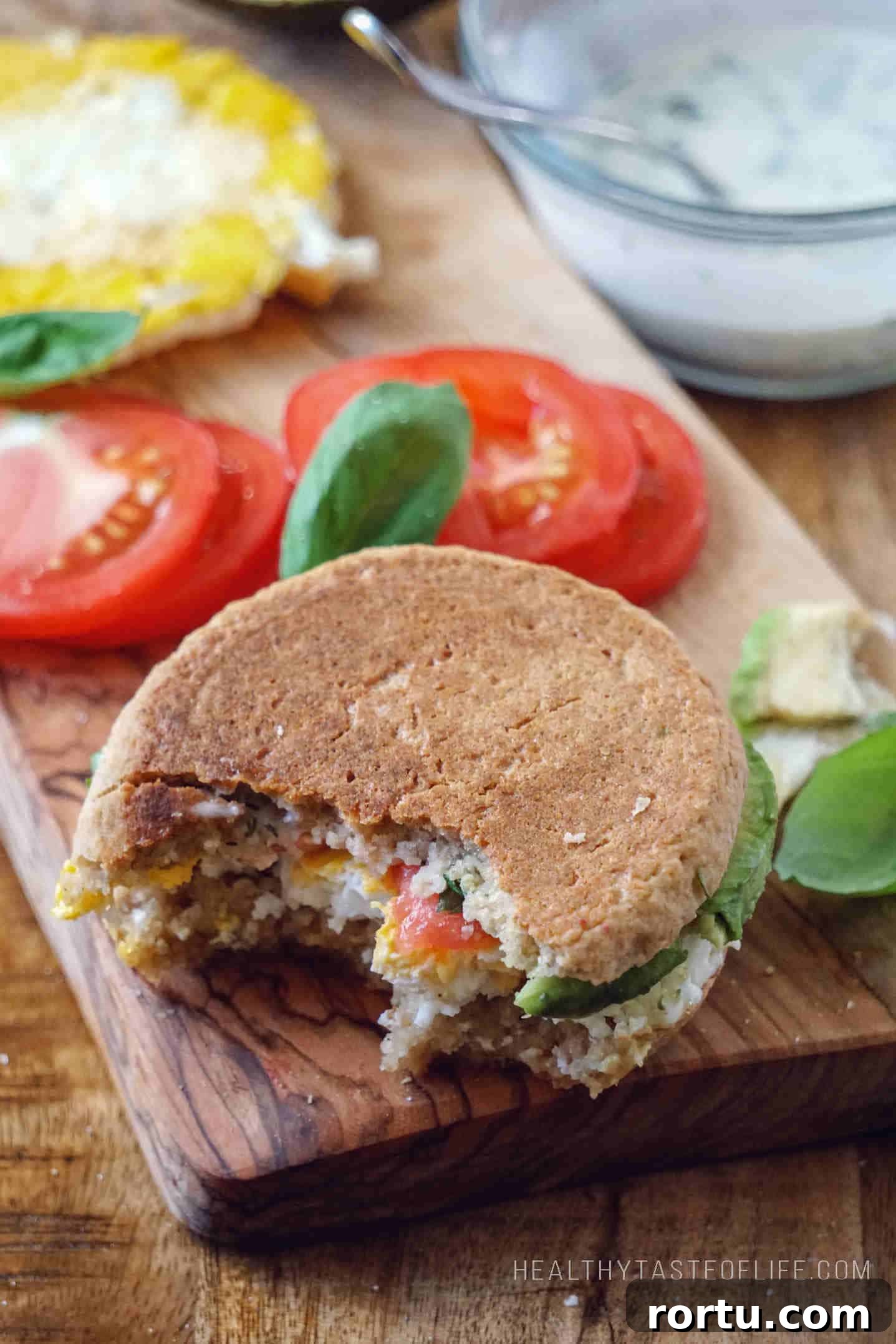gluten-free English muffin sandwich with avocado, egg and tomato as savory option (on the right) and sweet option served with butter spread and jam