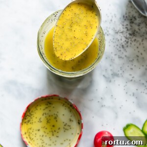 Creamy Poppy Seed Dressing Recipe for Salads and Slaws 4 Top down shot of a spoon scooping poppyseed salad dressing out of a glass jar