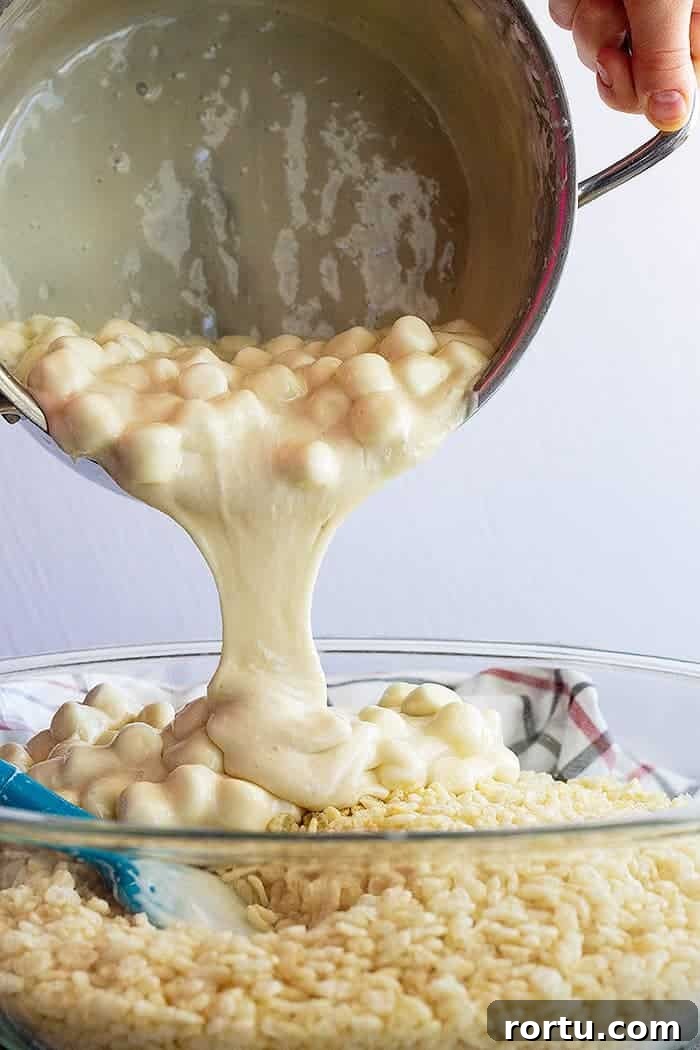 Homemade Gooey Rice Krispie Treats for Perfect Snacktime 3 pouring marshmallow mixture into rice krispies