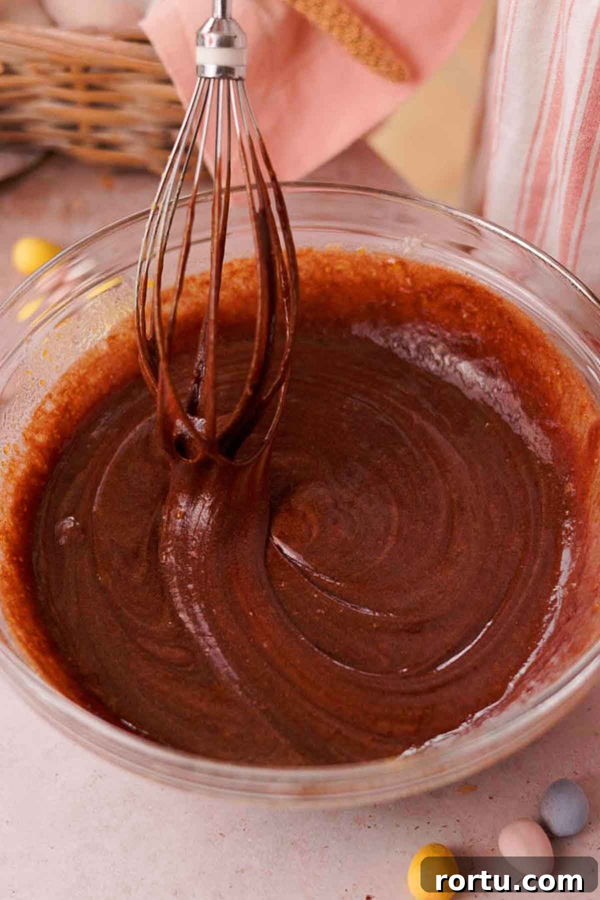 Mini Egg Chocolate Brownies with Melted Candy Centers 7 whisking brownie batter with whisk in clear glass bowl