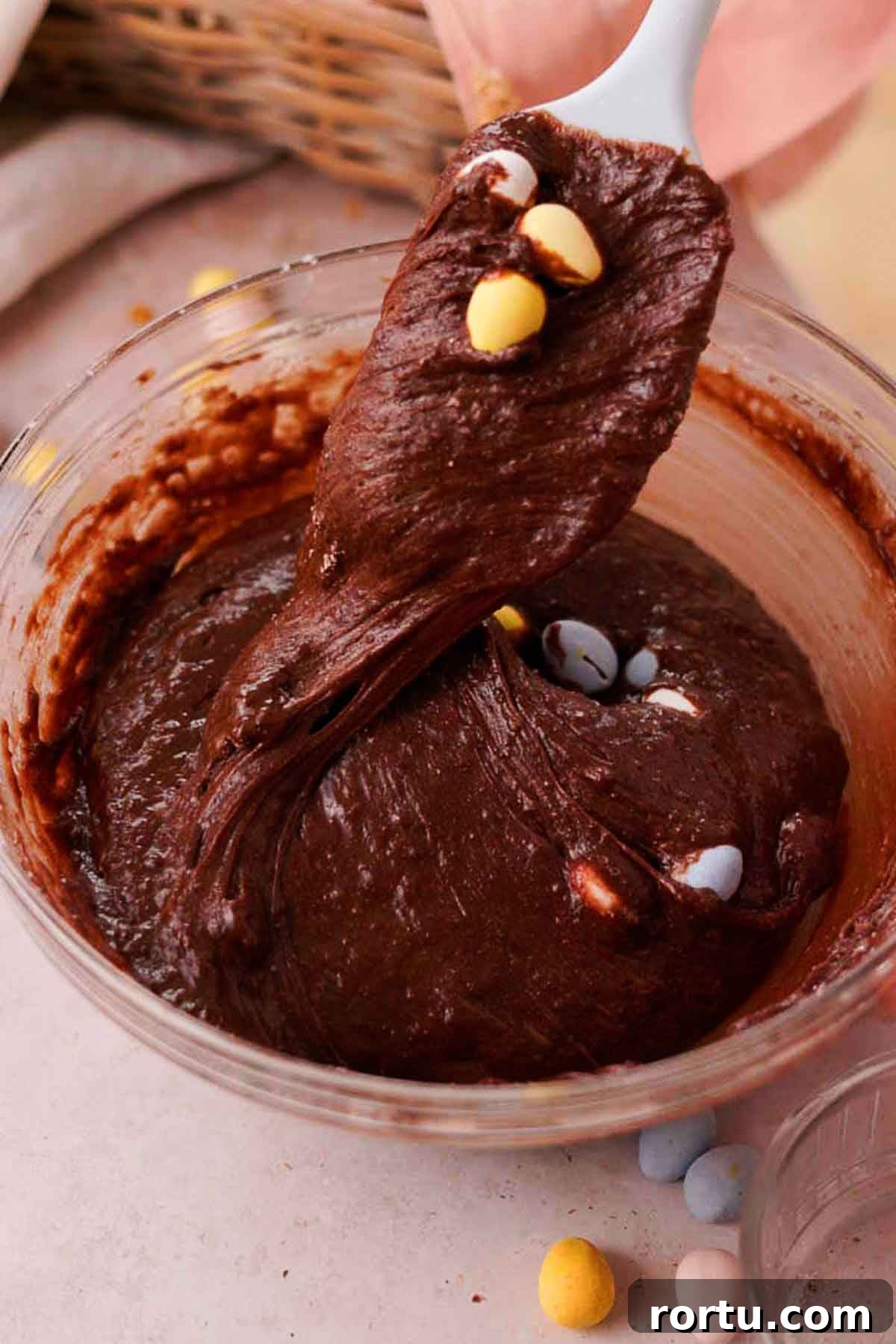 Mini Egg Chocolate Brownies with Melted Candy Centers 9 folding chocolate mini eggs into brownie batter with a silicone spatula