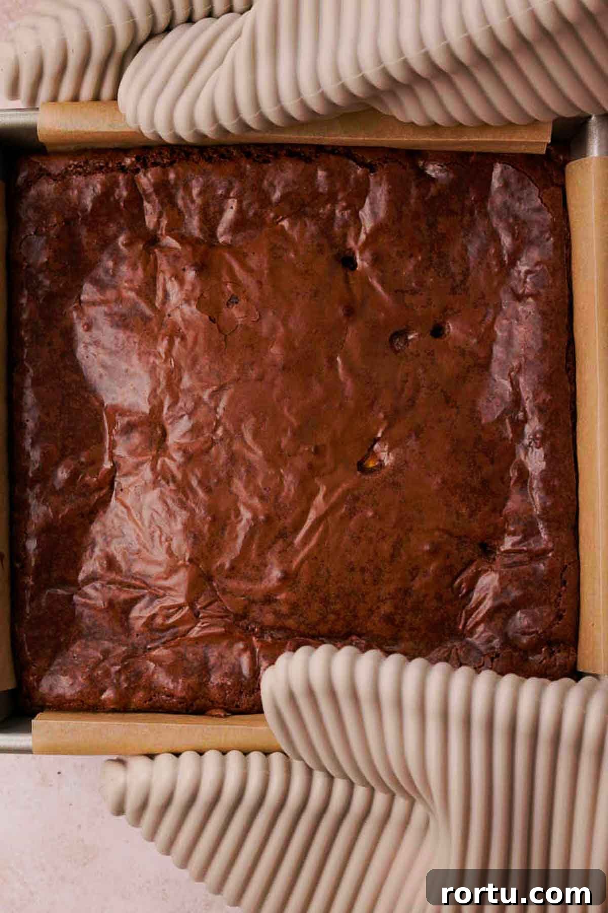 Mini Egg Chocolate Brownies with Melted Candy Centers 10 holding baking pan with hot mini egg brownies using oven mitts