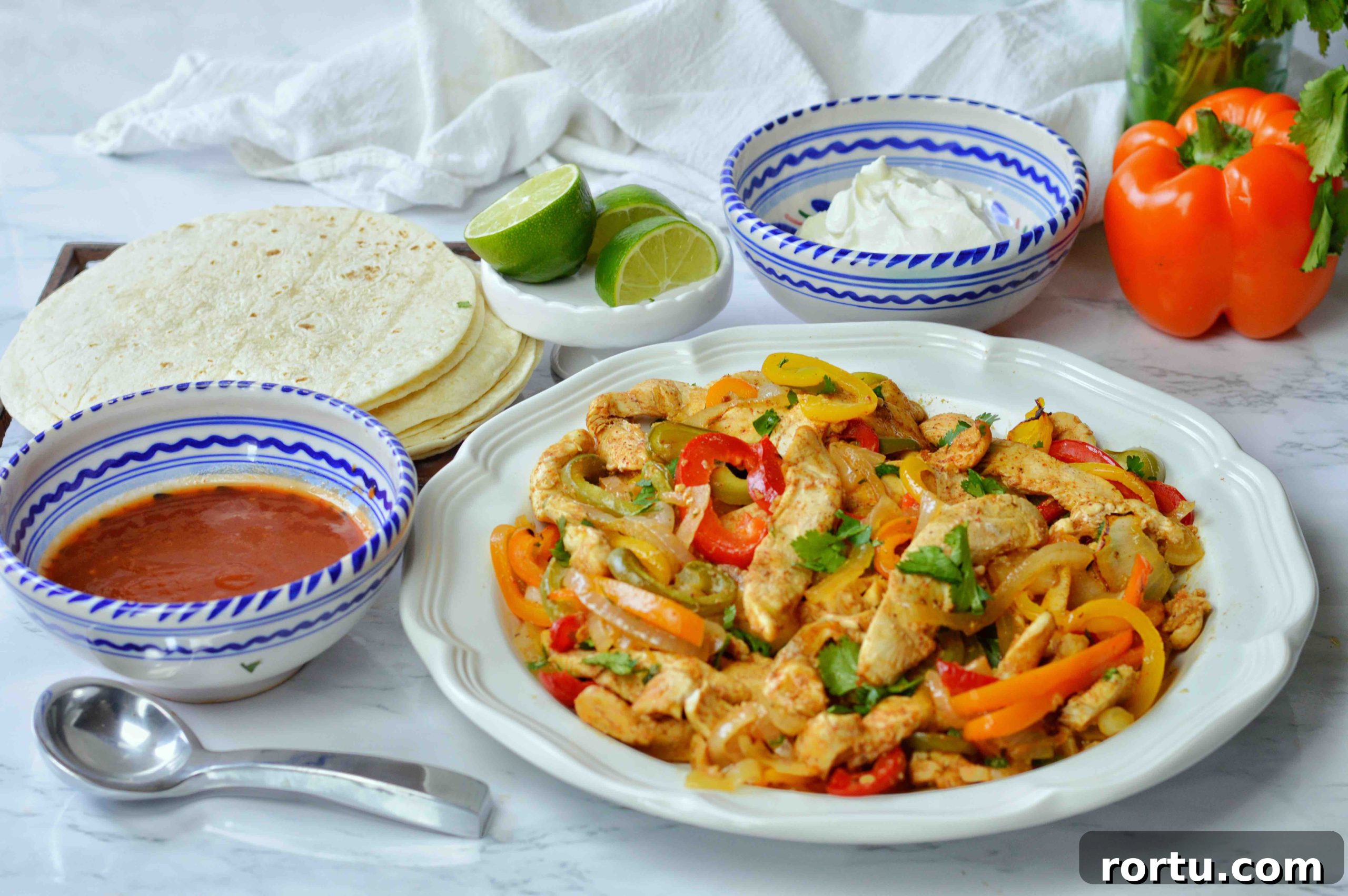 Sheet Pan Chicken Fajitas Recipe — Quick One-Pan Meal 8 platter full of chicken fajitas with peppers and onions plus bowls of condiments