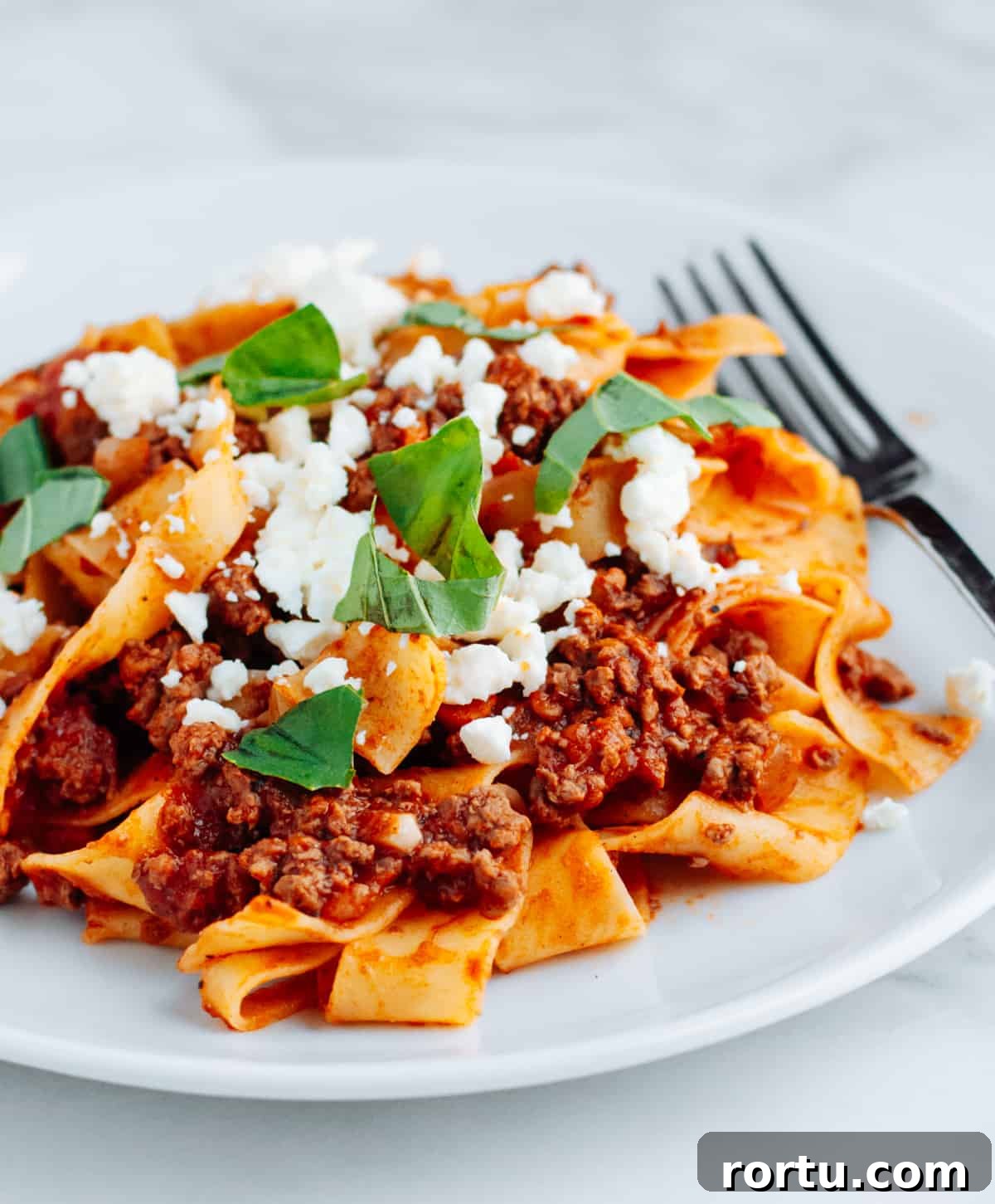 Lamb Ragu Recipe: Slow-Simmered Sauce with Parmesan 2 Lamb Ragu with pasta on a white plate.