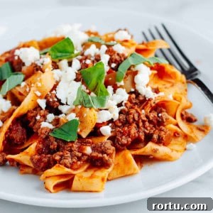 Lamb Ragu Recipe: Slow-Simmered Sauce with Parmesan 15 Lamb Ragu with pasta on a white plate.