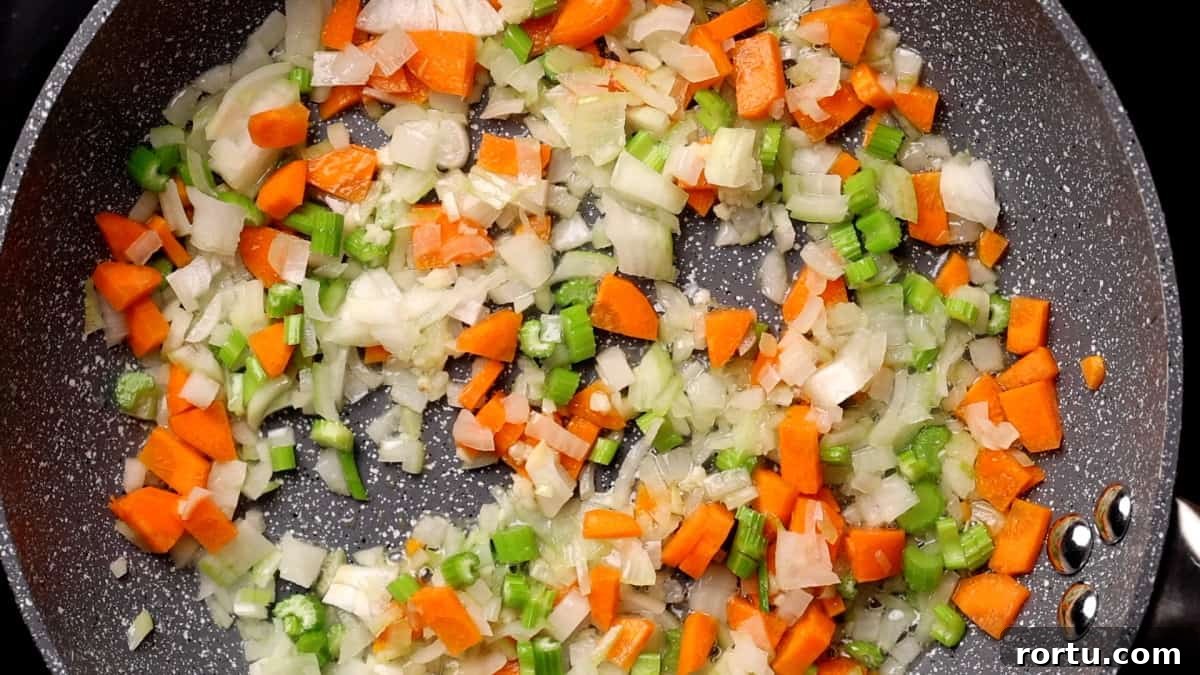 Lamb Ragu Recipe: Slow-Simmered Sauce with Parmesan 6 Cooking onion carrot and celery in skillet.