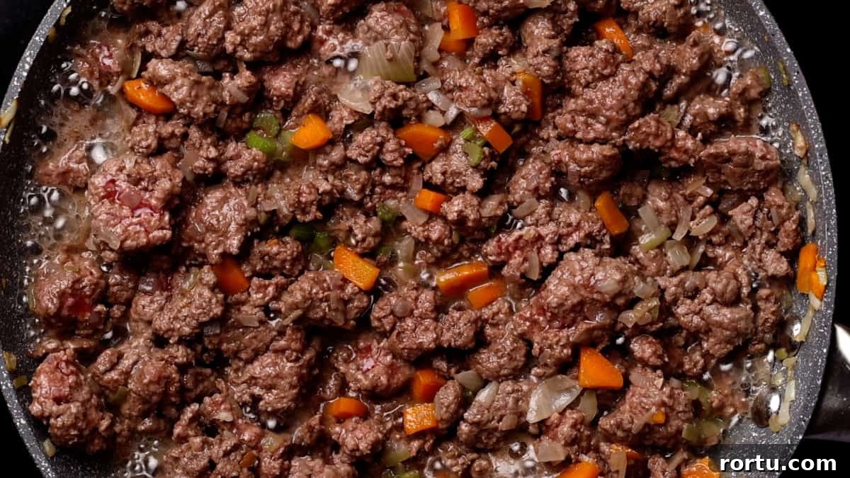 Lamb Ragu Recipe: Slow-Simmered Sauce with Parmesan 8 Reducing wine in lamb mixture.