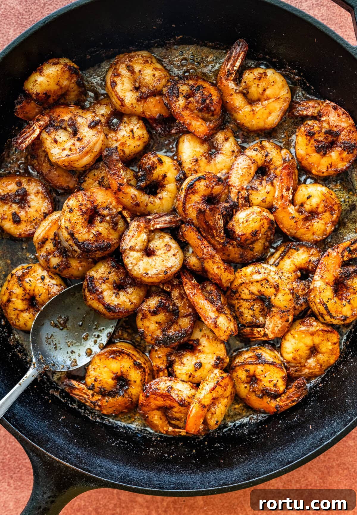 10-Minute Blackened Shrimp Recipe for Flavorful Weeknight Meals 11 Spoon mixing the shrimp in the skilelt.
