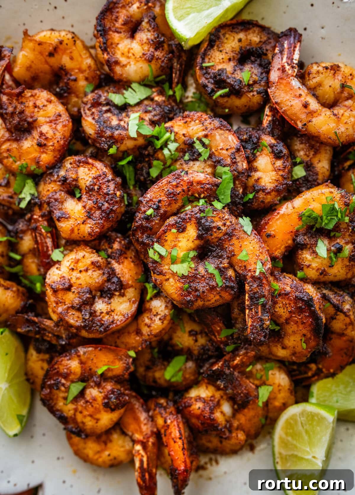 10-Minute Blackened Shrimp Recipe for Flavorful Weeknight Meals 12 Blackened shrimp on a plate with garnish.