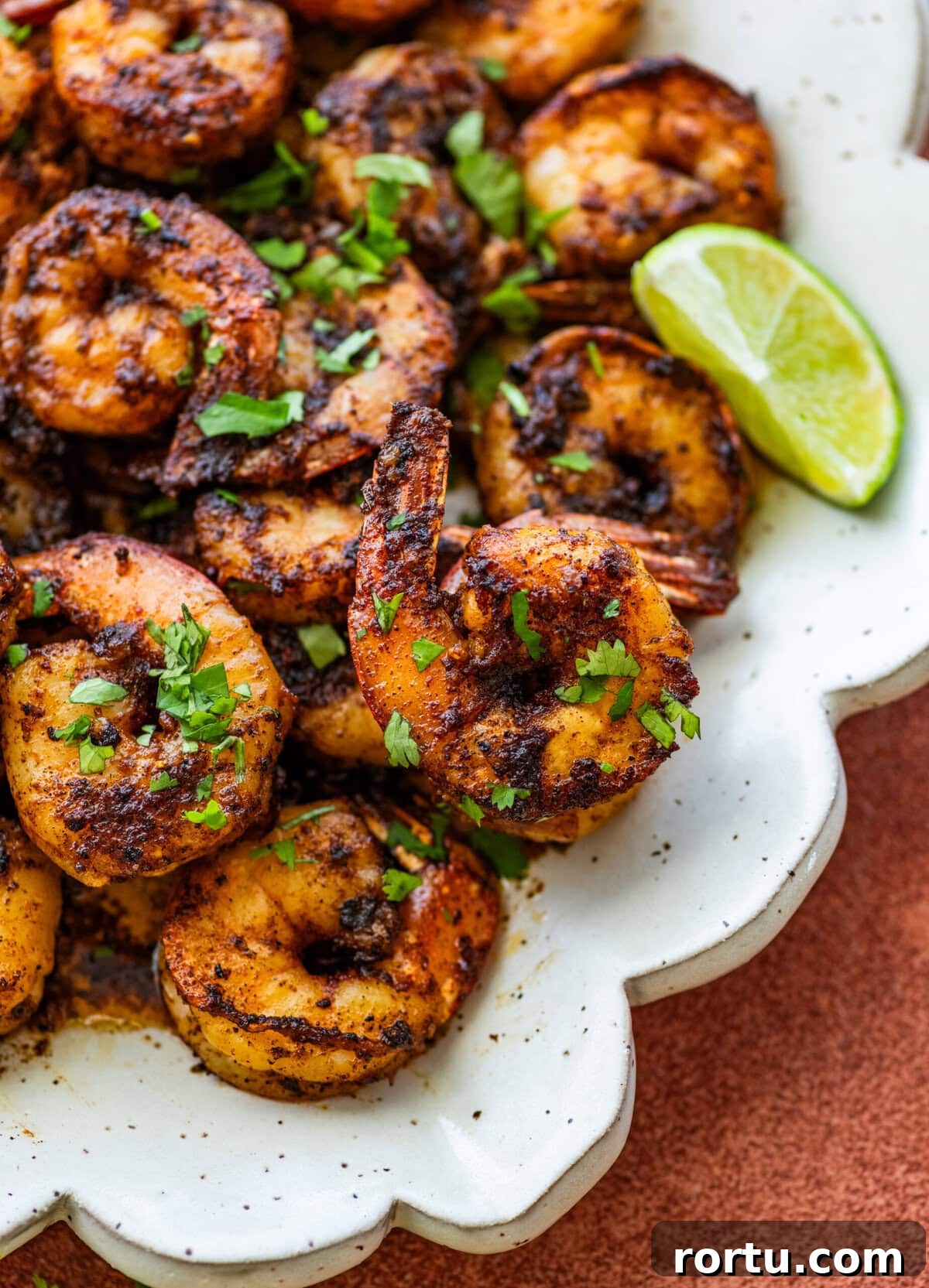 10-Minute Blackened Shrimp Recipe for Flavorful Weeknight Meals 13 Blackened shrimp on a plate with garnish.