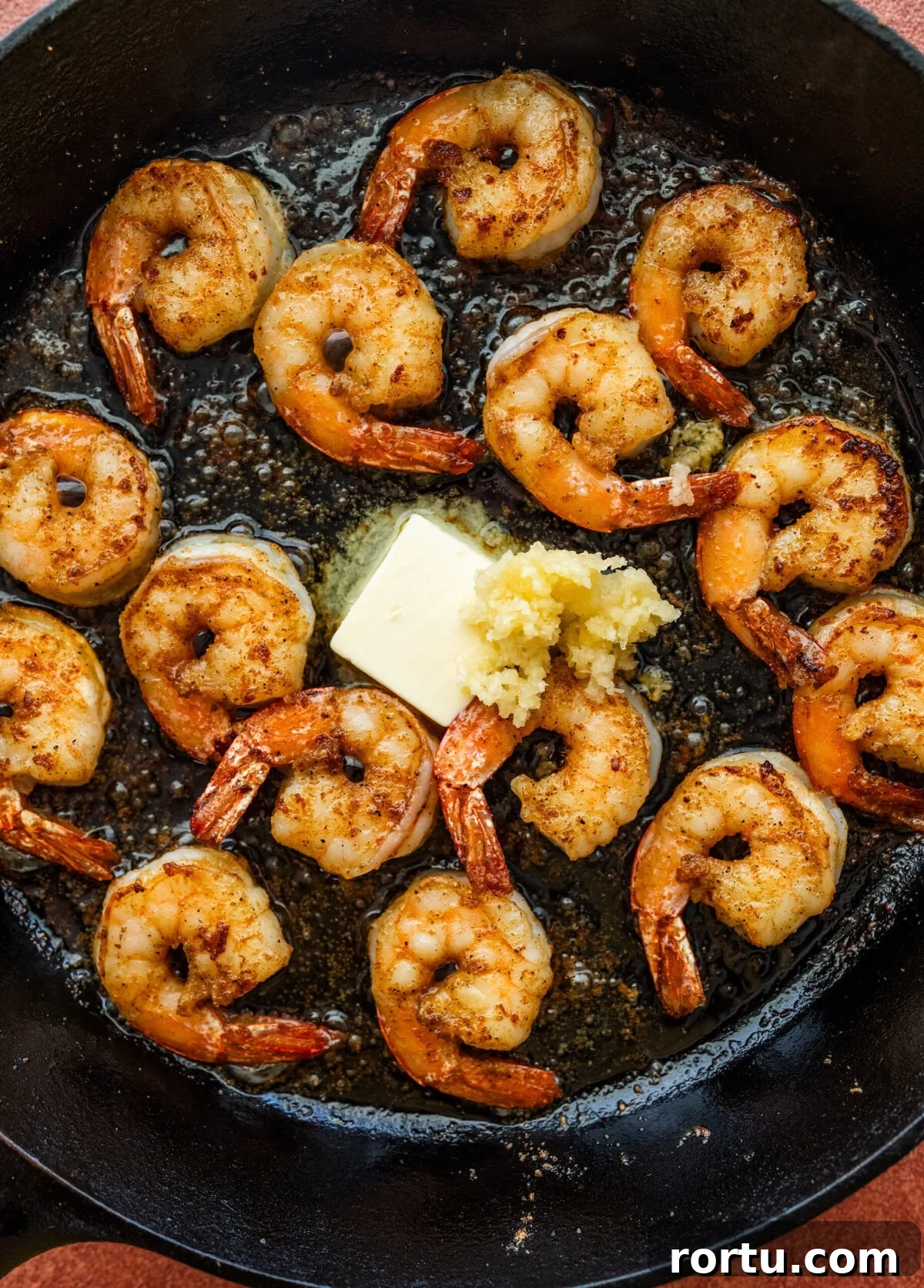 10-Minute Blackened Shrimp Recipe for Flavorful Weeknight Meals 10 Butter and garlic added to the skillet of shrimp.