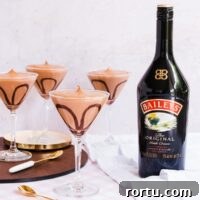 Creamy Baileys Chocolate Mousse Recipe 12 Four cocktail glasses filled with Baileys mousse, with a Baileys bottle in the background.