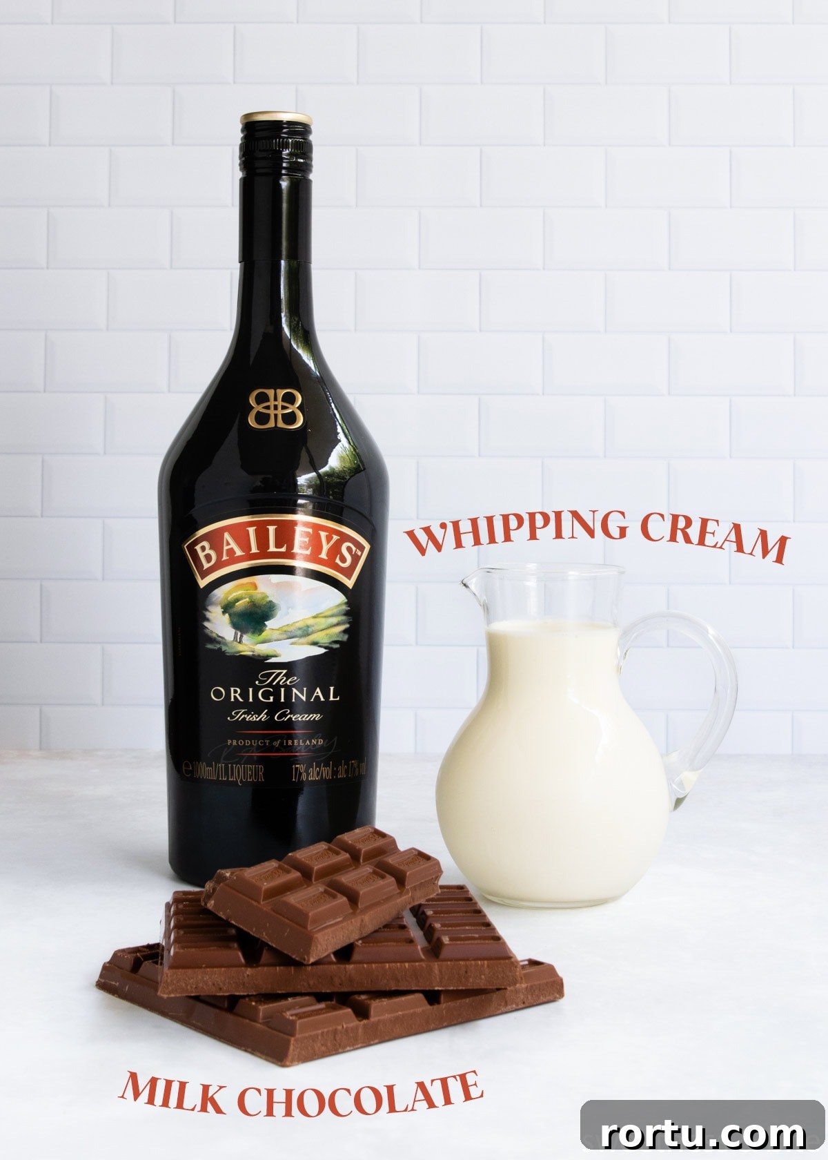 Creamy Baileys Chocolate Mousse Recipe 3 The baileys mousse ingredients - milk chocolate, whipping cream and baileys irish cream, on a white tiled background.