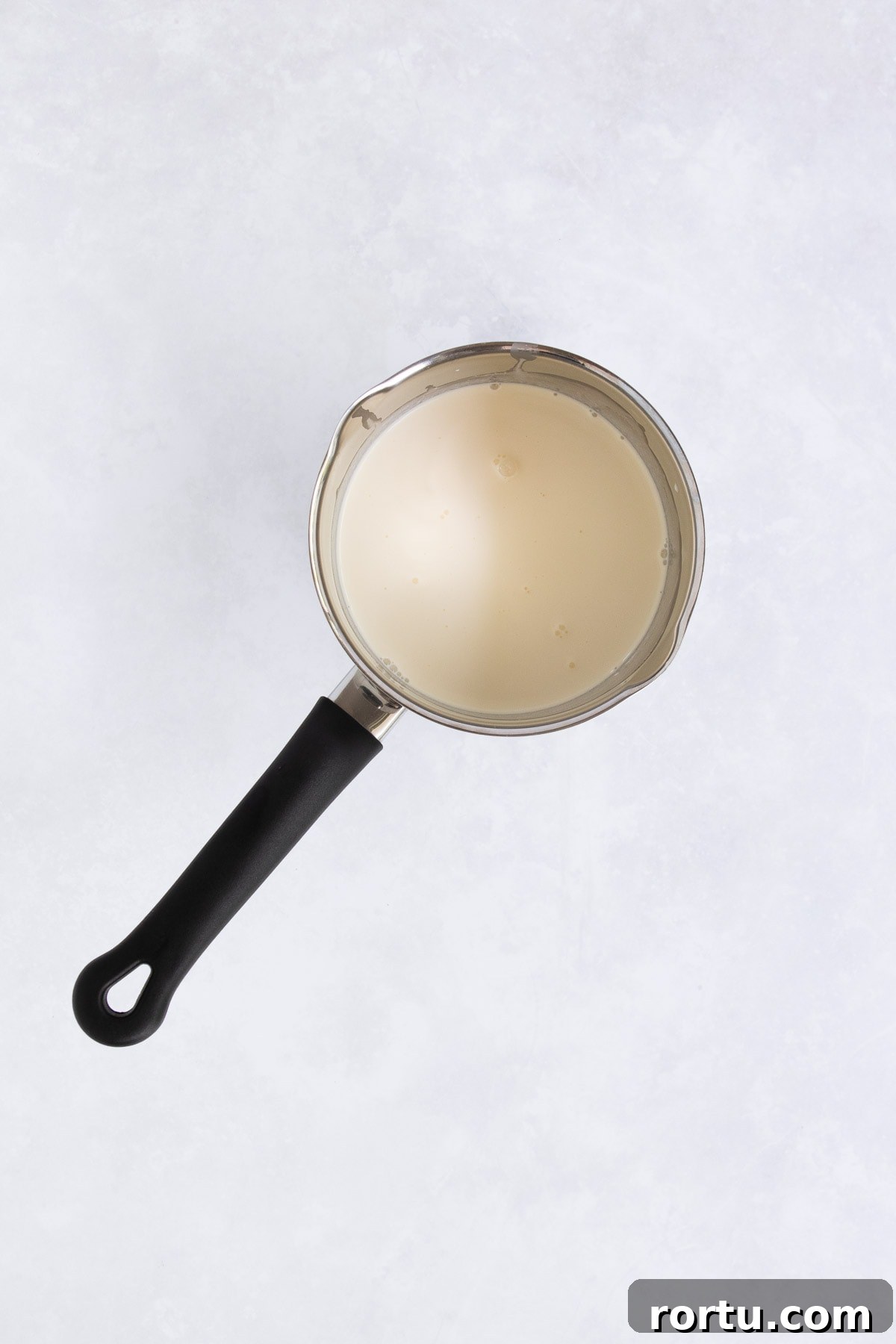 Creamy Baileys Chocolate Mousse Recipe 5 Cream in a small stainless steel saucepan with a black handle.