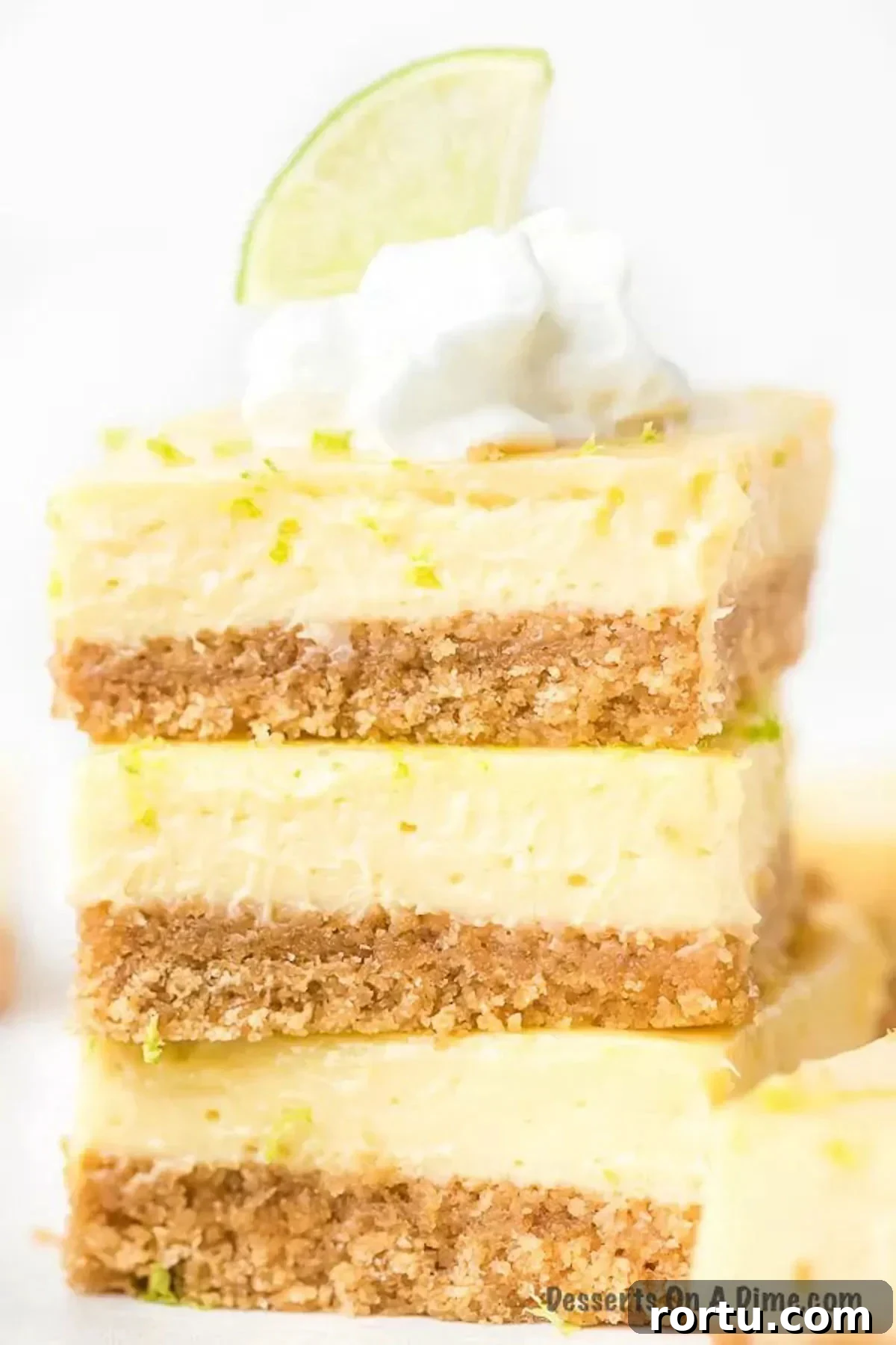 Key Lime Bars stacked with fresh lime on top