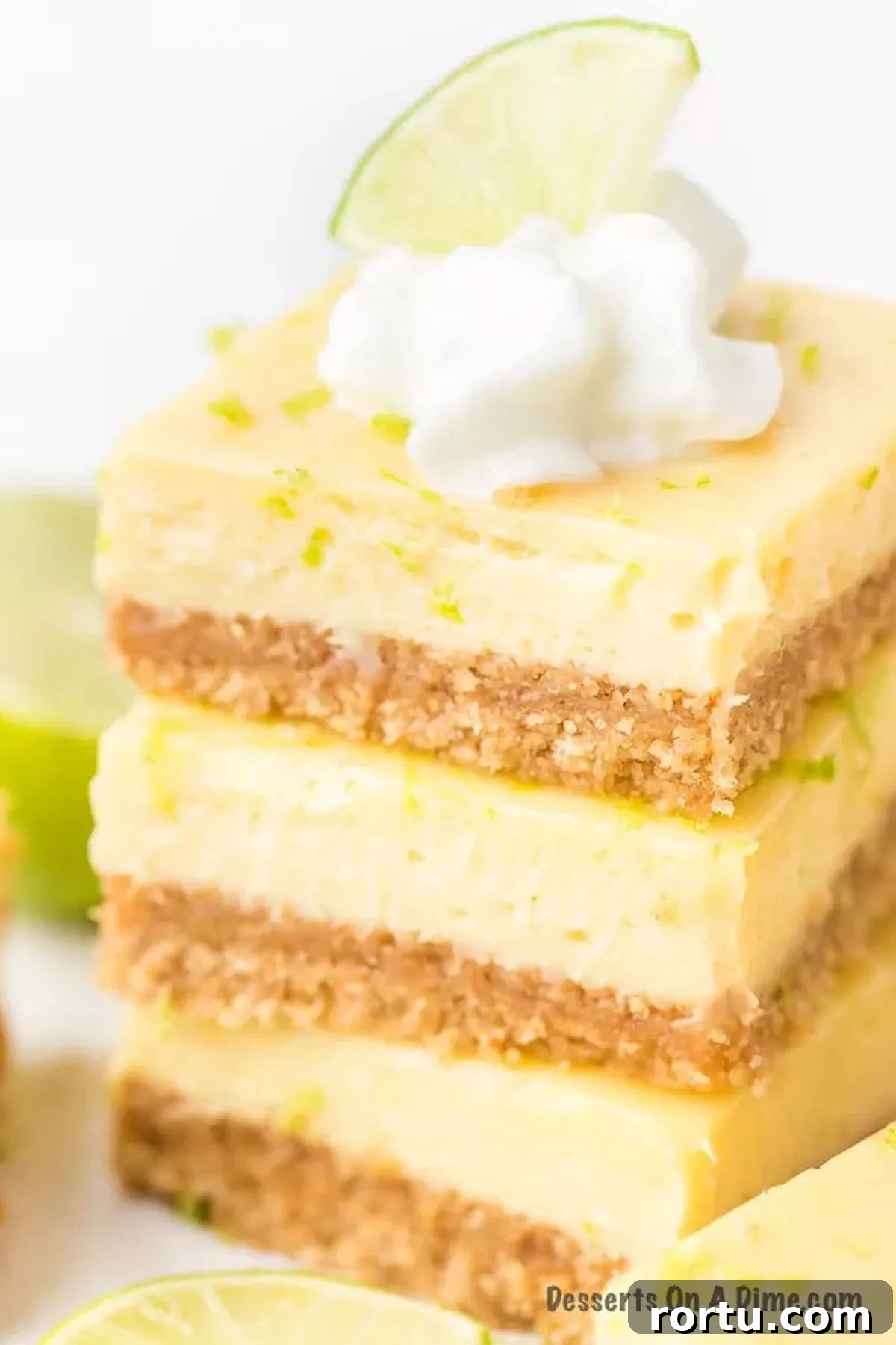 Key Lime Bars stacked with fresh lime on top