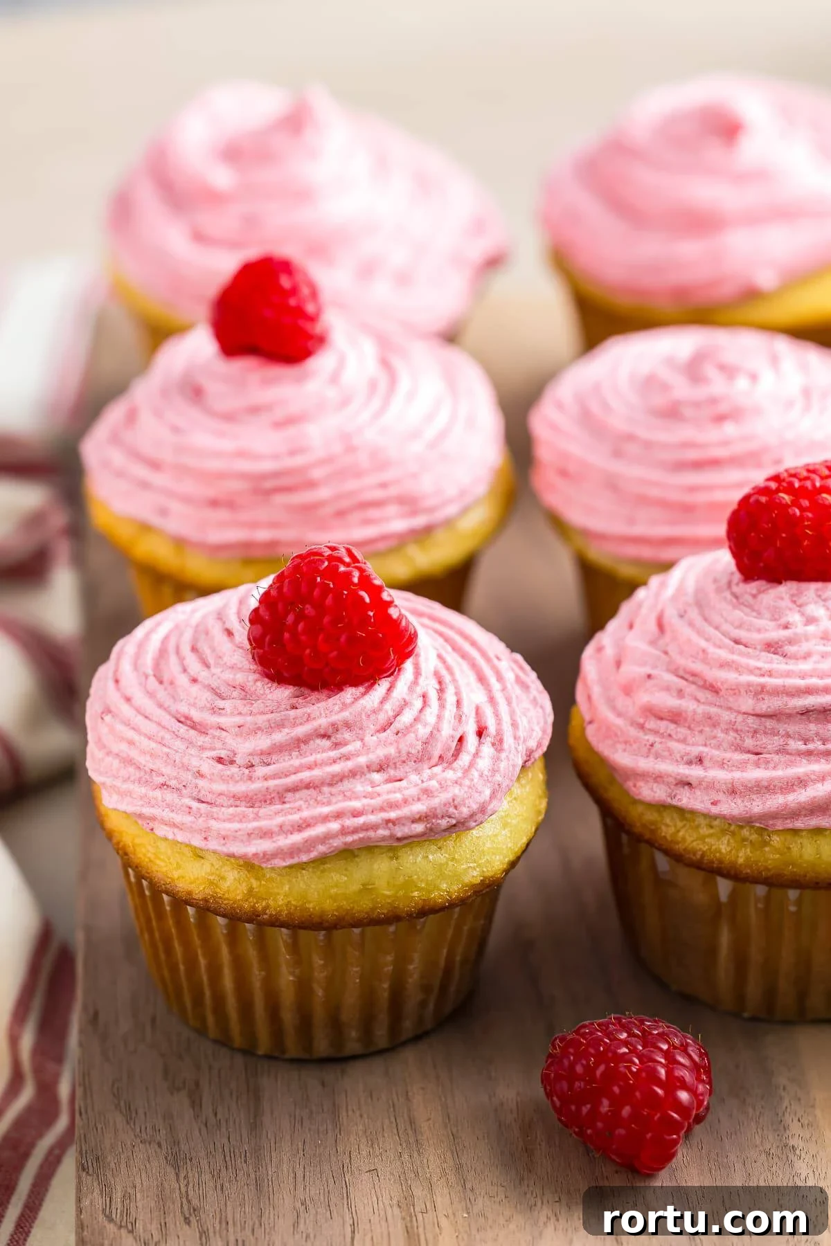 Almond Cupcakes with Fresh Raspberry Buttercream Frosting, a simple, beautiful yummy dessert! Raspberry Cupcakes on a wooden serving platter