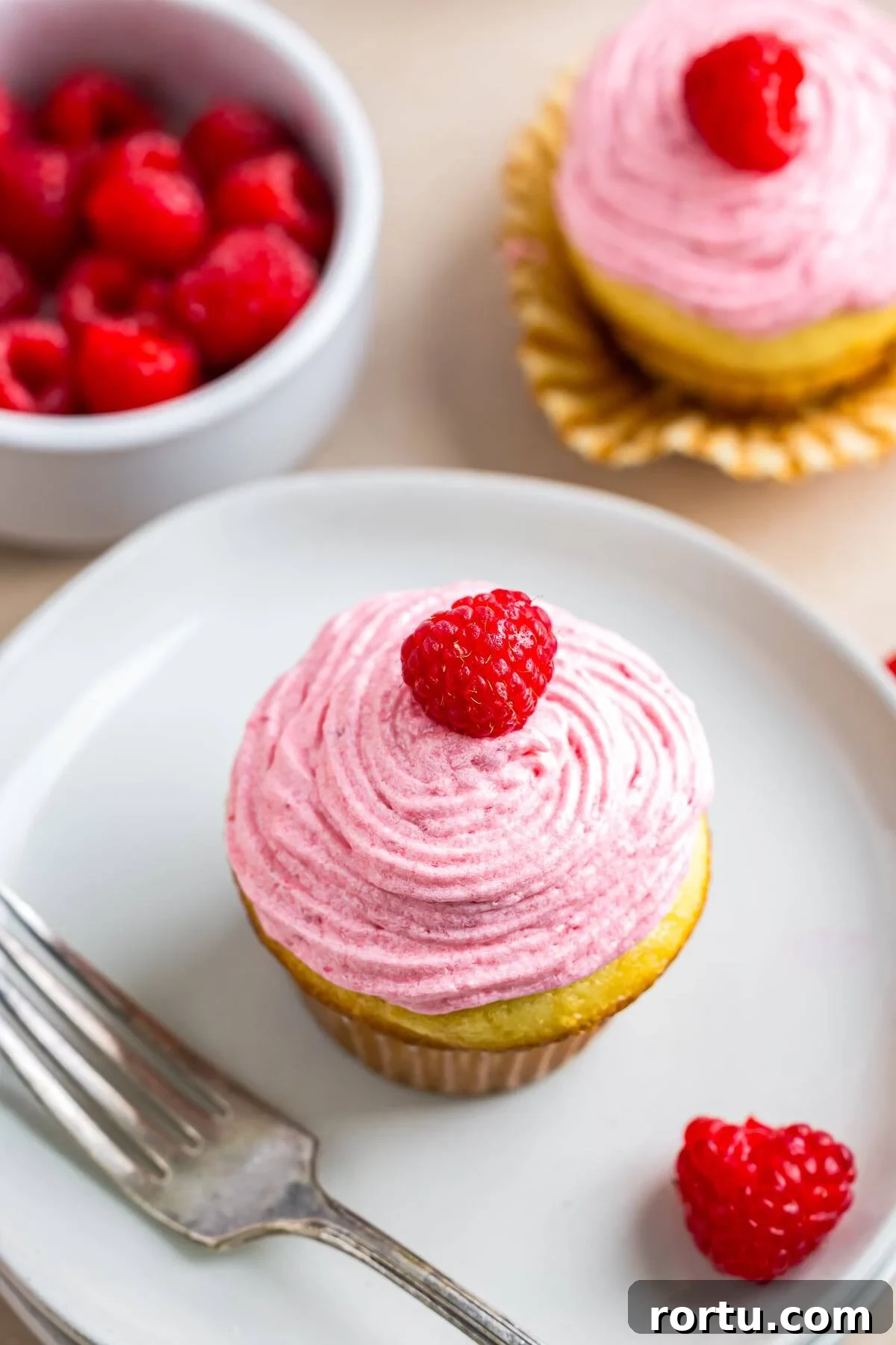 Almond Raspberry Cupcakes with Frangipane Filling Recipe 2 overhead image Raspberry Cupcakes on white plate