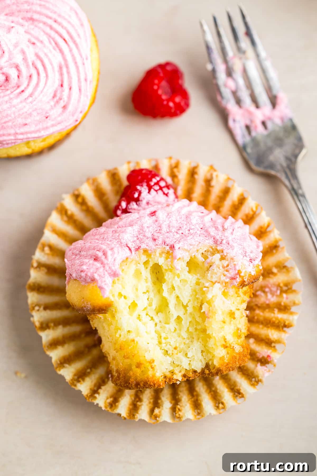 Almond Raspberry Cupcakes with Frangipane Filling Recipe 3 Raspberry Cupcakes on its side with a bite taken out