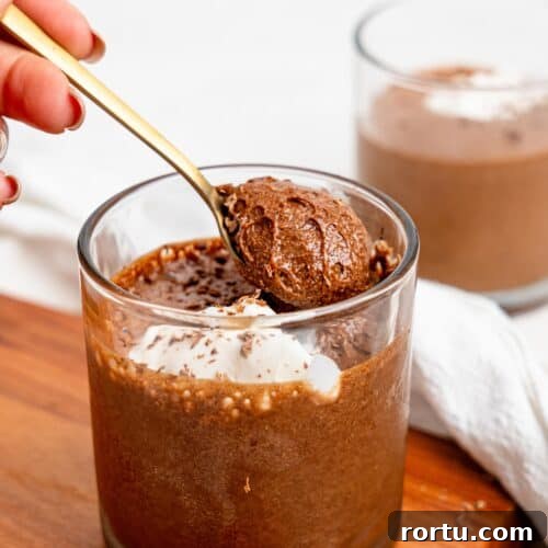 High-Protein Chocolate Mousse Recipe for Muscle Recovery 10 Spooning Chocolate Protein Mousse in a glass cup.