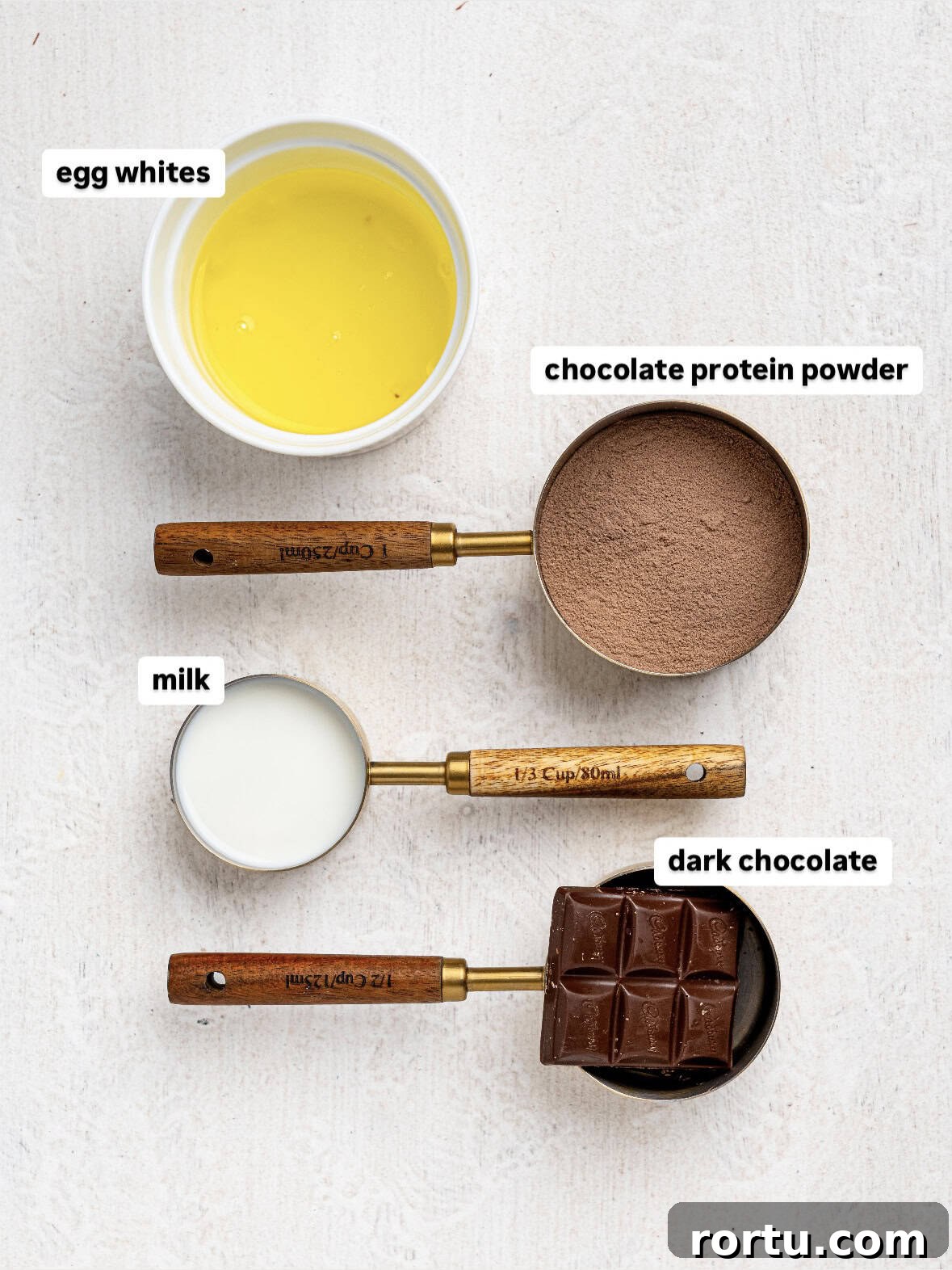 High-Protein Chocolate Mousse Recipe for Muscle Recovery 5 Ingredients needed to make protein chocolate mousse: egg whites, chocolate protein powder, milk, and dark chocolate.