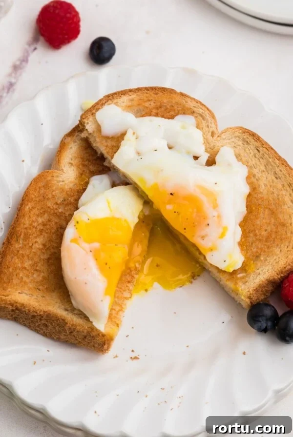 Air fryer poached egg on toast cut in half with yolk spilling out.