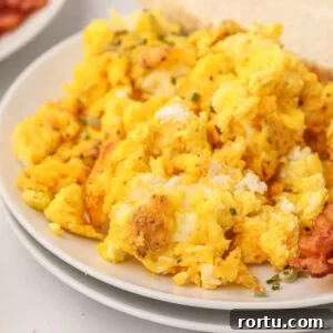 Air fryer scrambled eggs on a white plate ready to serve.