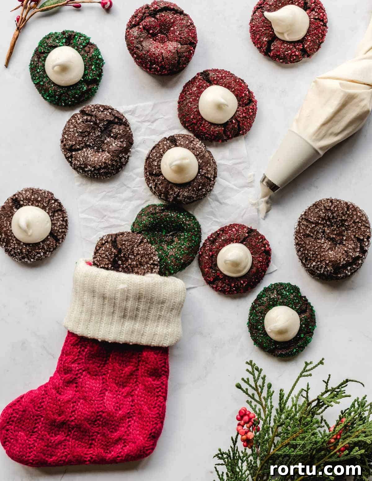 Filling chocolate thumbprint cookies for Christmas with peppermint filling.