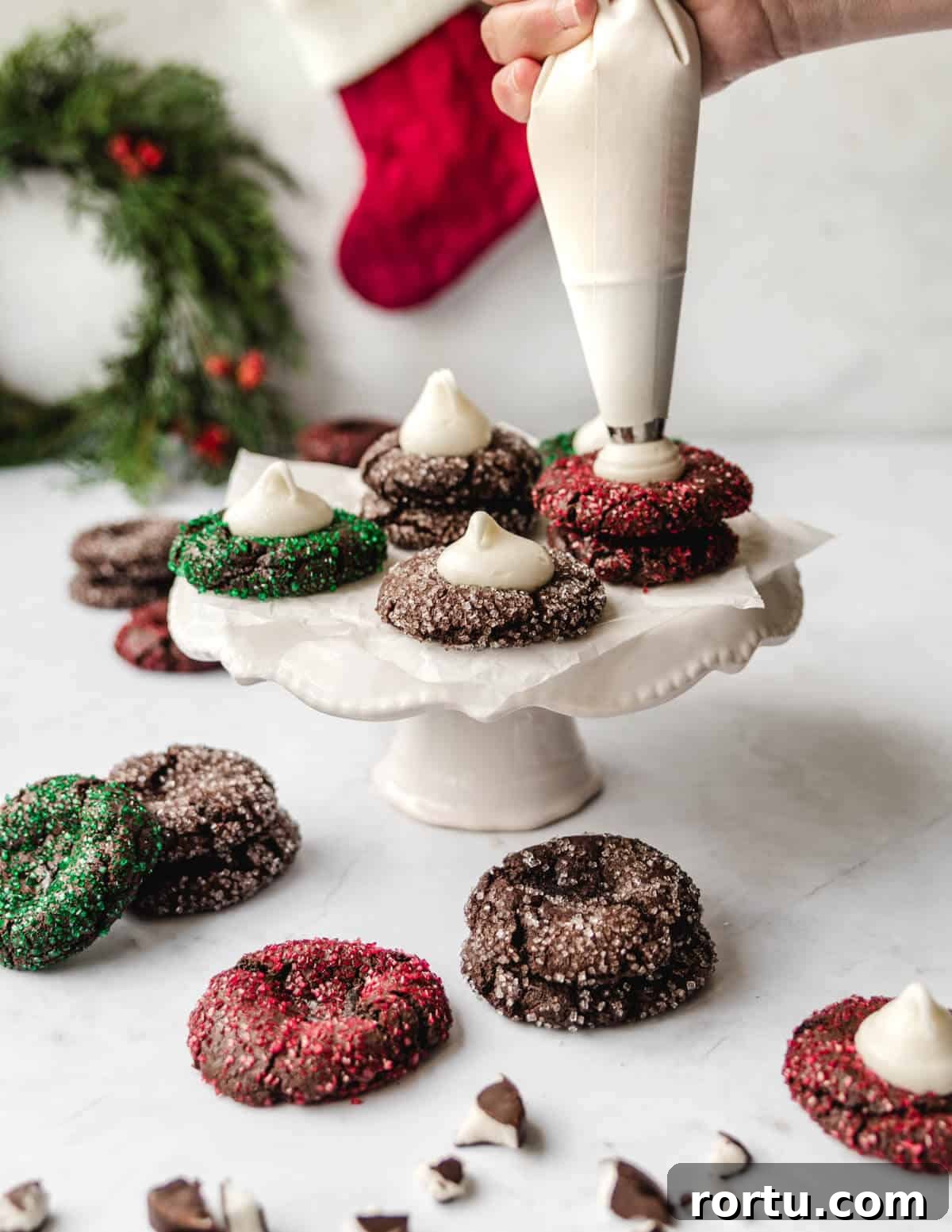 Piping peppermint schnapps filling into chocolate thumbprint cookies for Christmas.
