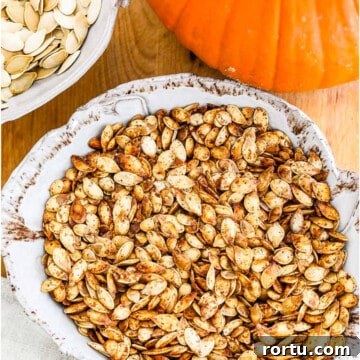 A ceramic dish full of golden brown roast pumpkin seeds.