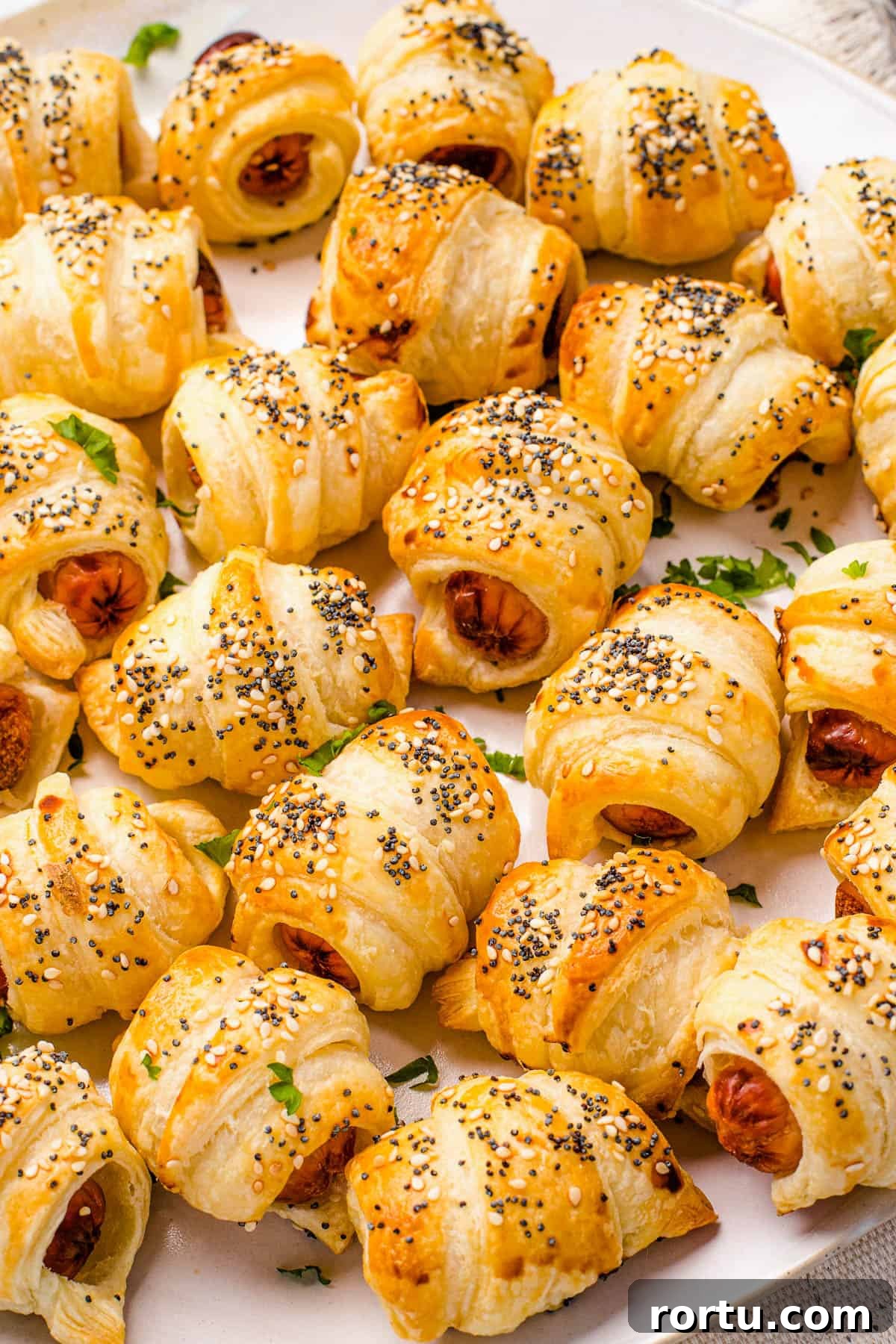 Close up shot of crescent roll hot dogs sprinkled with sesame and poppy seeds.