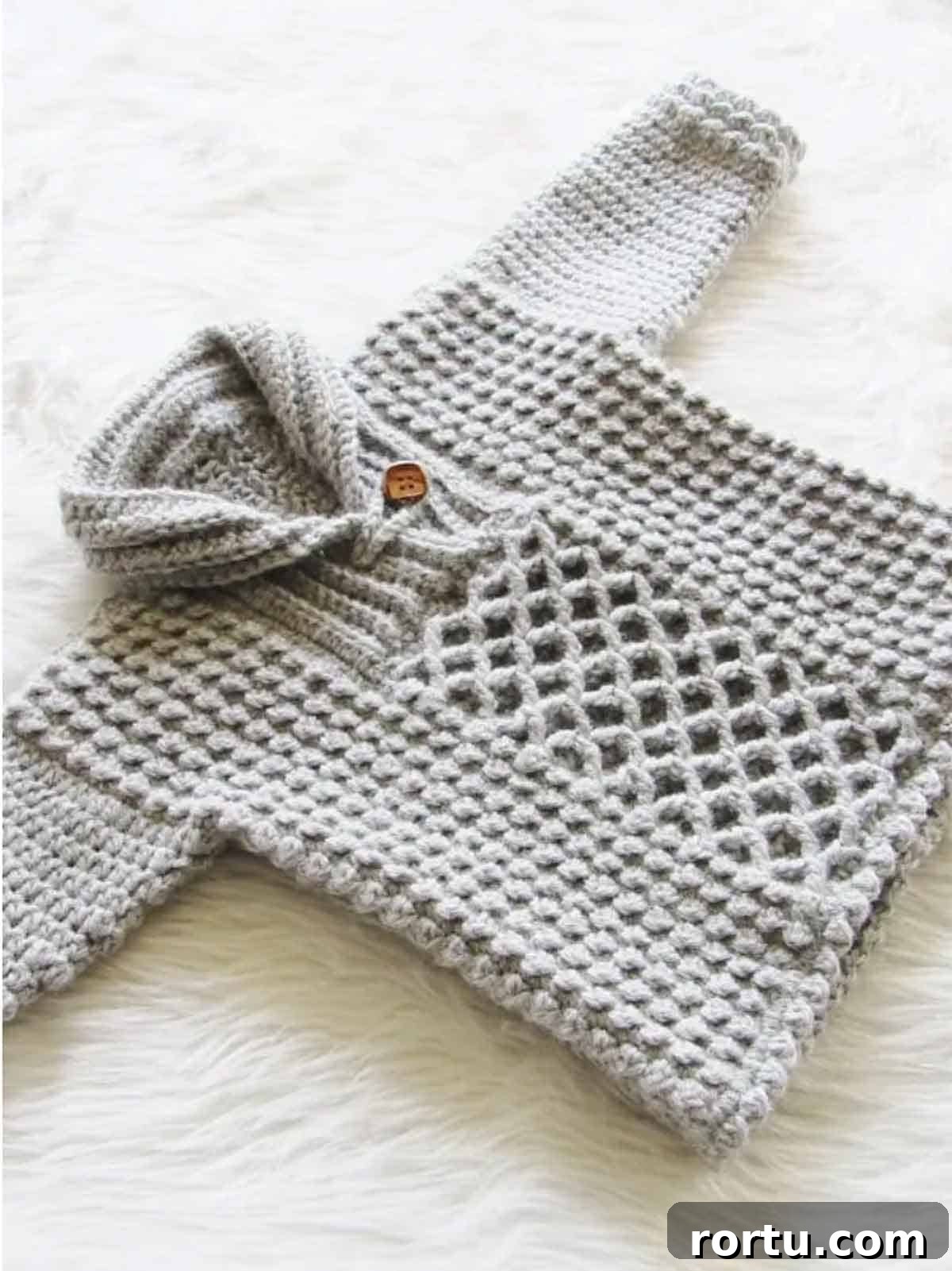 Image shows a gray baby boy pull over sweater laying on a white furry rug. -Skip To My Lou
