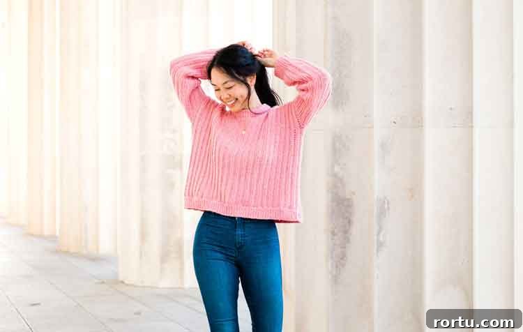 Image shows a woman wearing a pink ribbed oversized crochet sweater. -Skip To My Lou