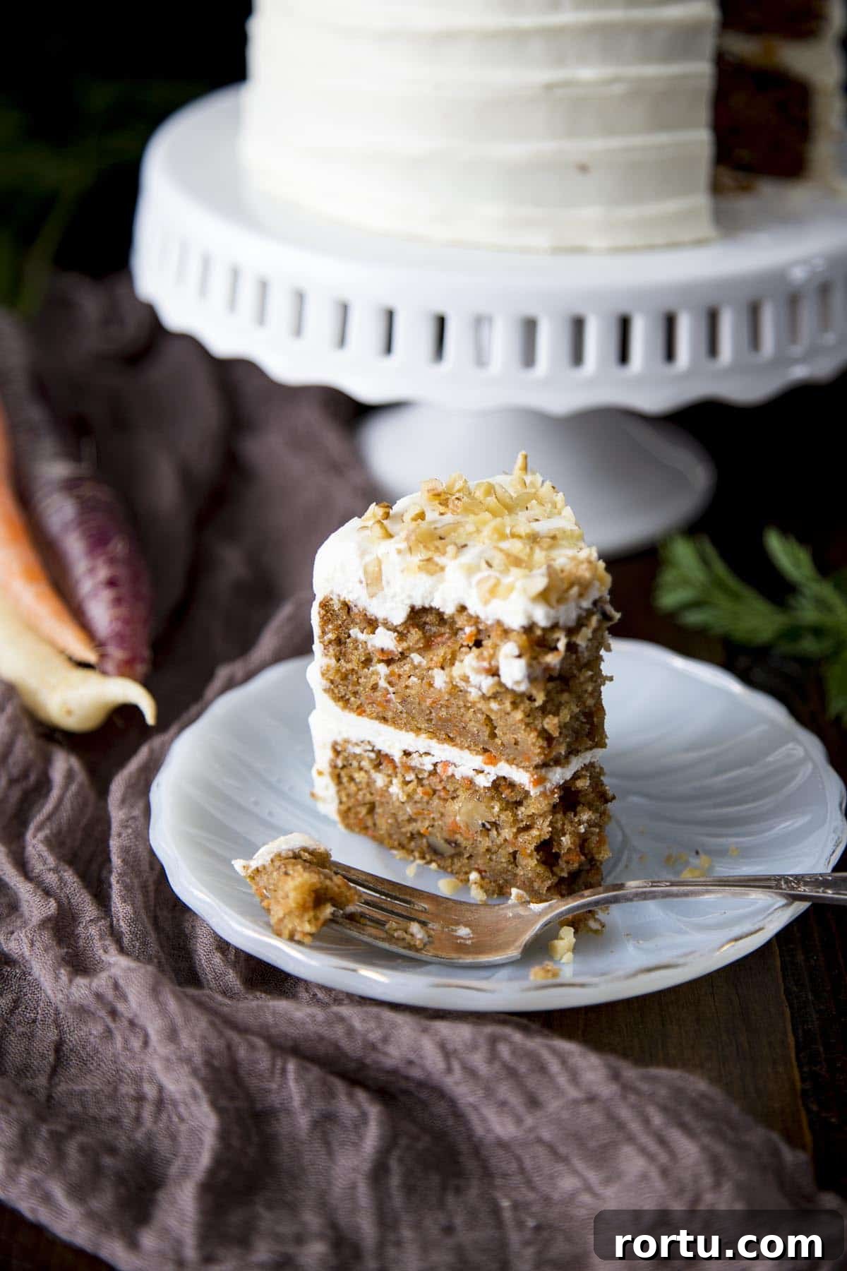 A slice of mini carrot cake being eaten.